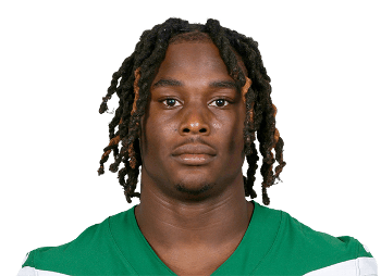 A young football player wearing a green jersey with black and orange braided hair, posing for a headshot against a solid background.